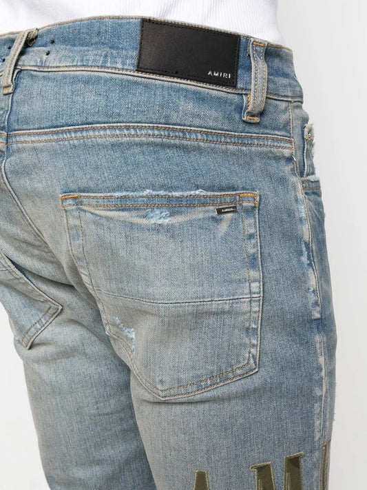 AMIRI logo-print distressed skinny jeans