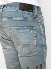 AMIRI logo-print distressed skinny jeans